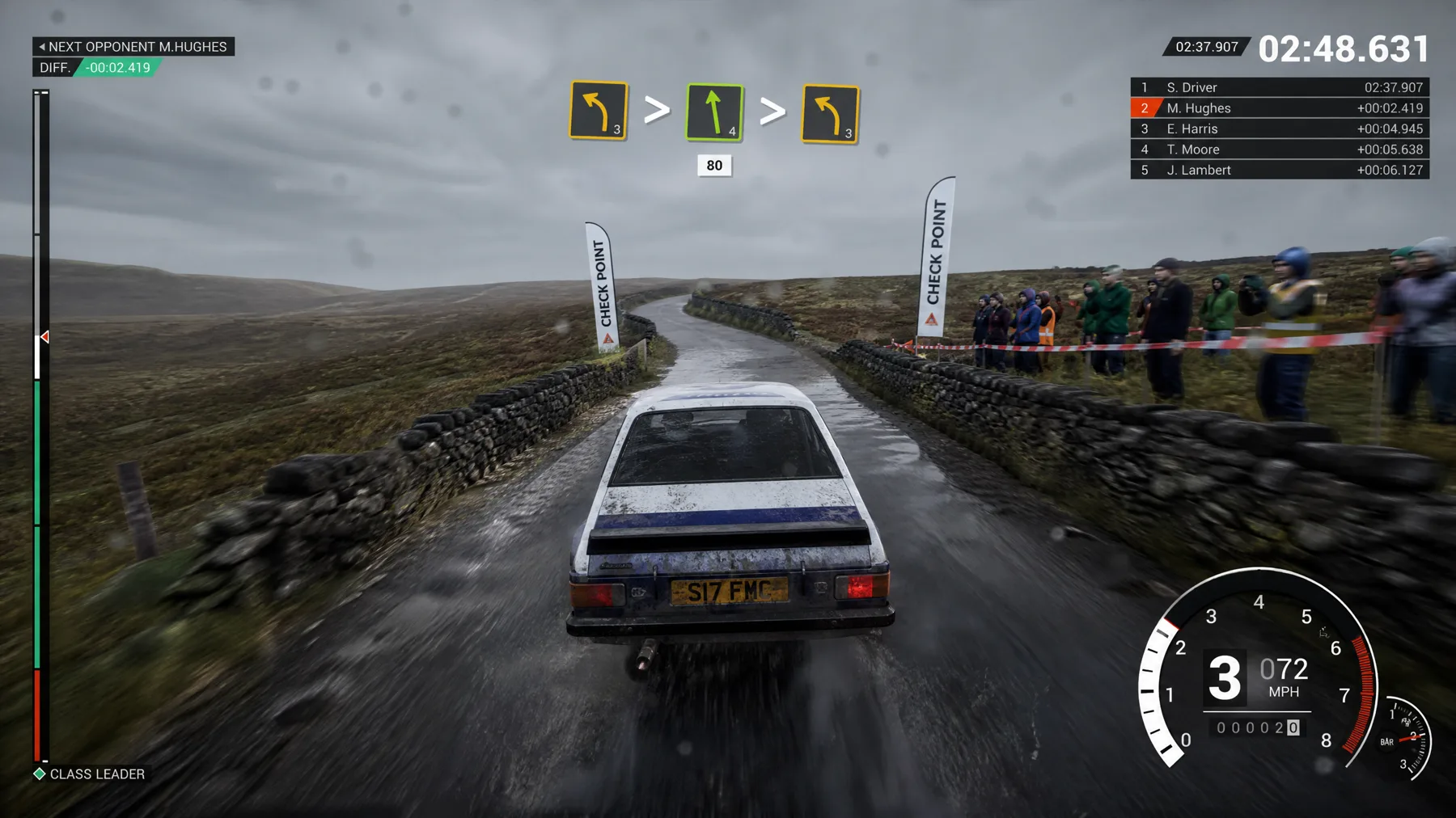 A classic rally car crosses a wet moor checkpoint with pace notes, grip and stage timer.